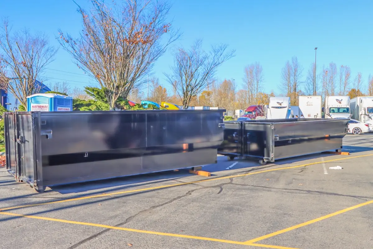 Professional dumpster rental service with roll-off container on residential driveway in Prairieville